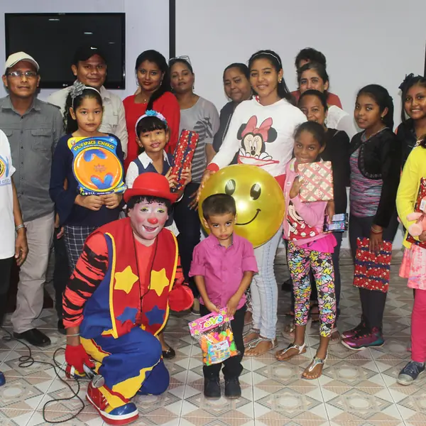 Niños y voluntarios con un payaso en una actividad de FUNARP