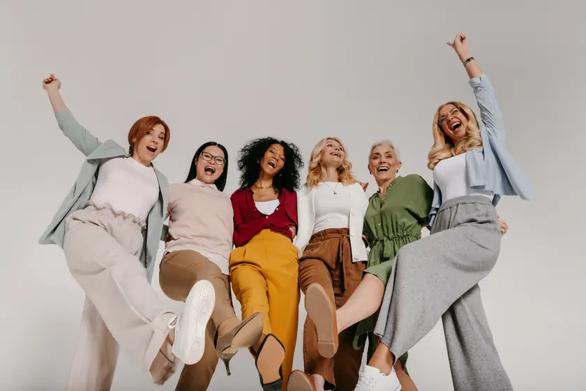 Grupo de mujeres de distintas edades celebrando juntas con alegría