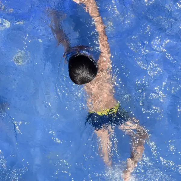 Niño nadando en una piscina, ejercicio de bajo impacto para las articulaciones